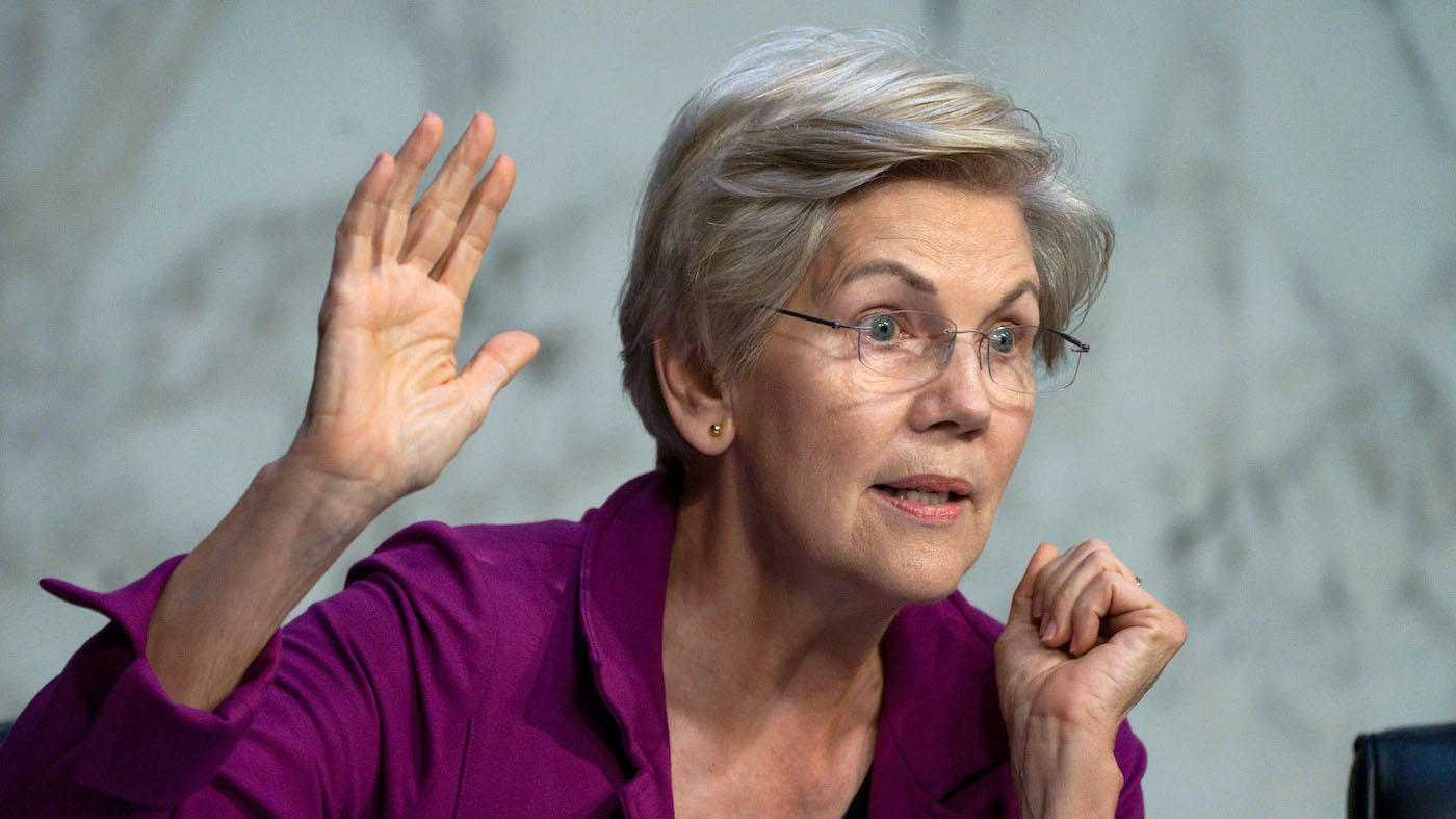 Elizabeth Warren speaking with one hand raised during a conversation or speech.