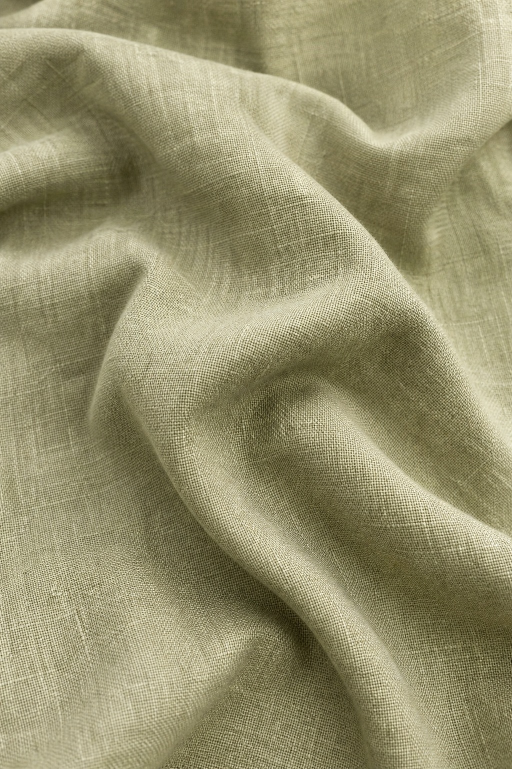 Vertical sage linen fabric with soft folds and a textured textile surface