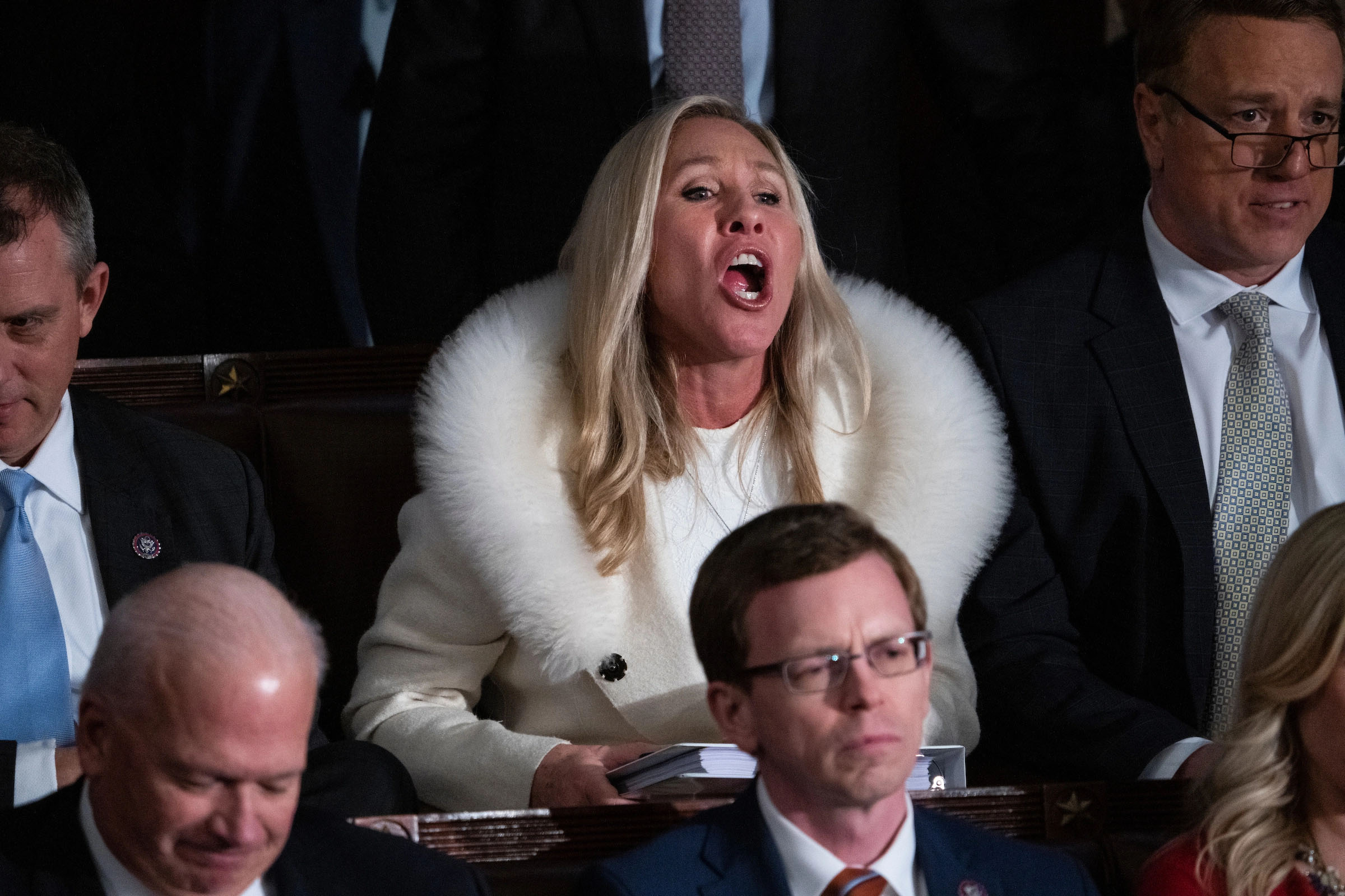 Woman in a fur coat speaking in a crowded political setting