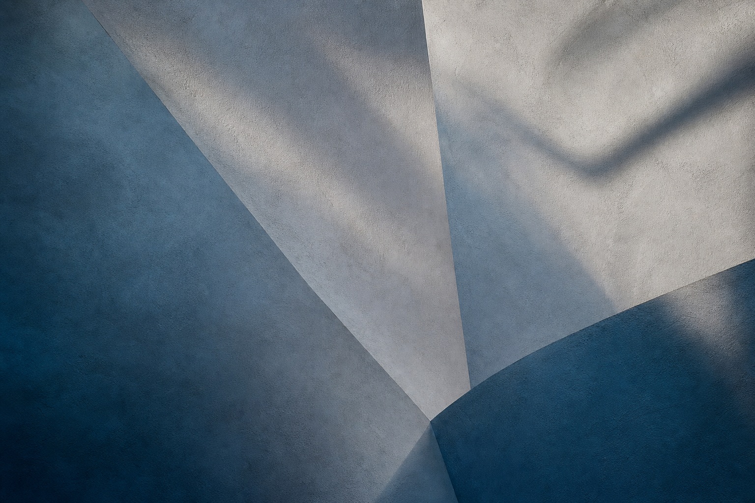 Abstract blue and warm plaster surfaces with sharp diagonal shadows.