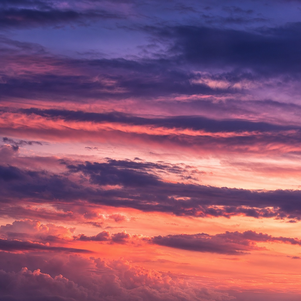 Dreamy evening sky with pink clouds and a purple gradient over the horizon.
