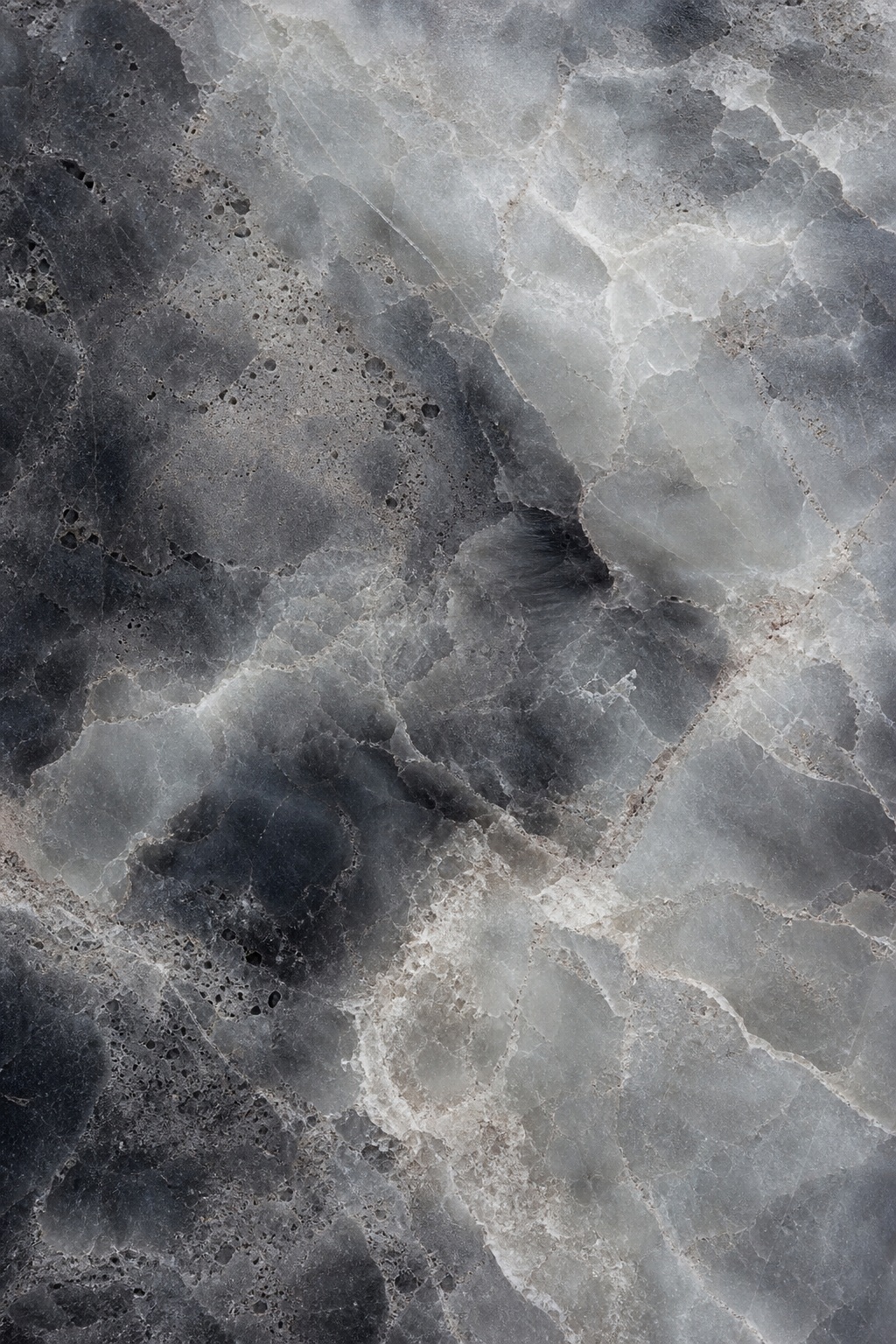 Dark smoky stone surface with soft white cloud veining and mottled mineral texture.