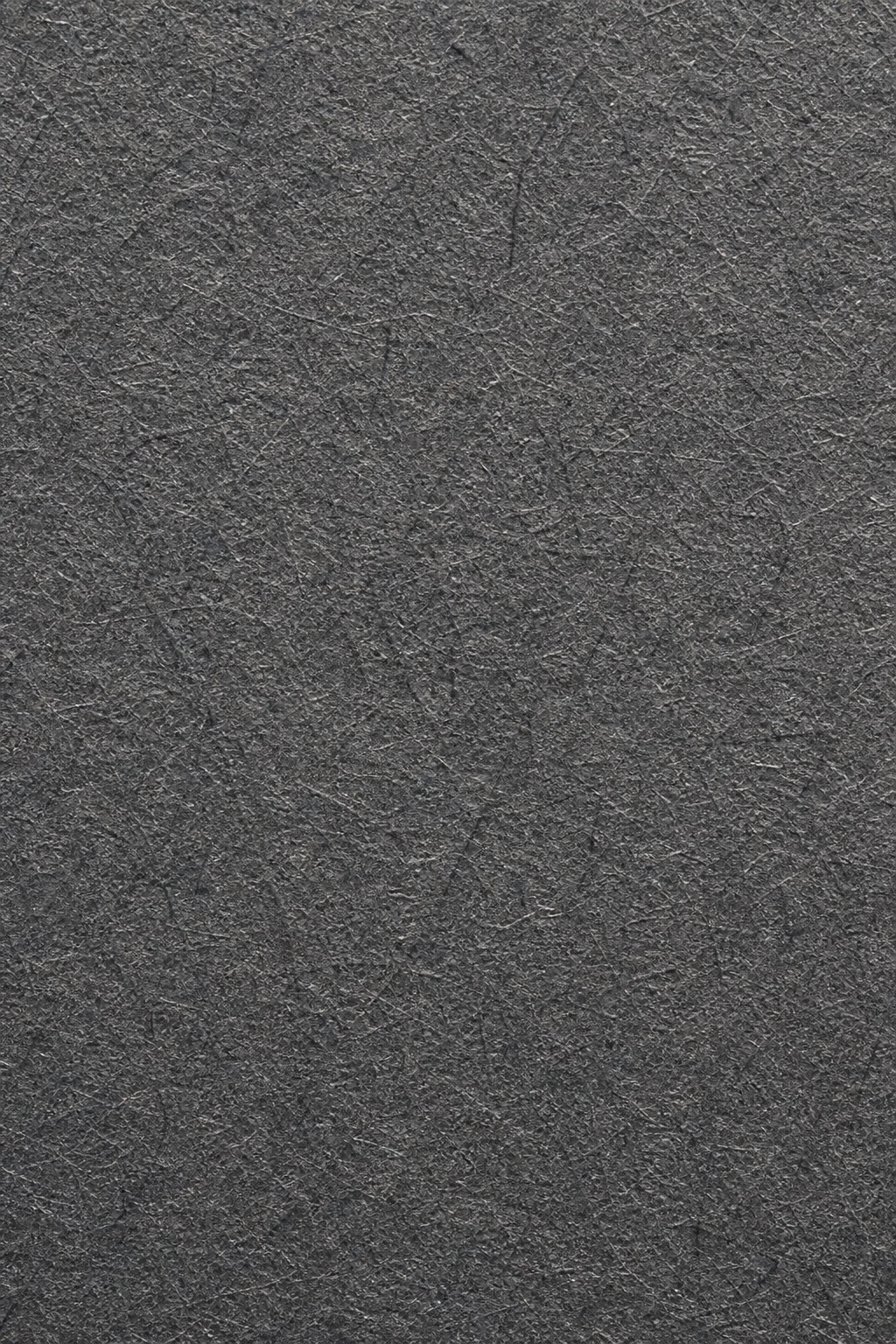 Dark charcoal paper texture with visible natural fiber grain and pressed surface detail.