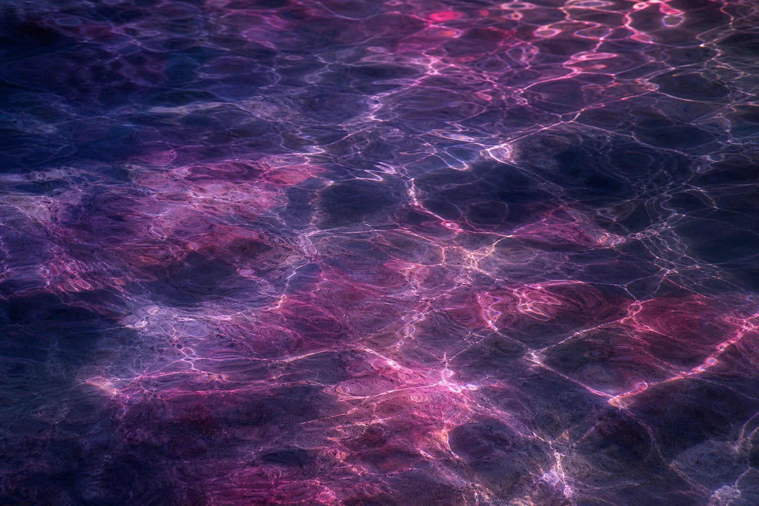 Magenta and navy prismatic light reflections rippling across a dark abstract surface.