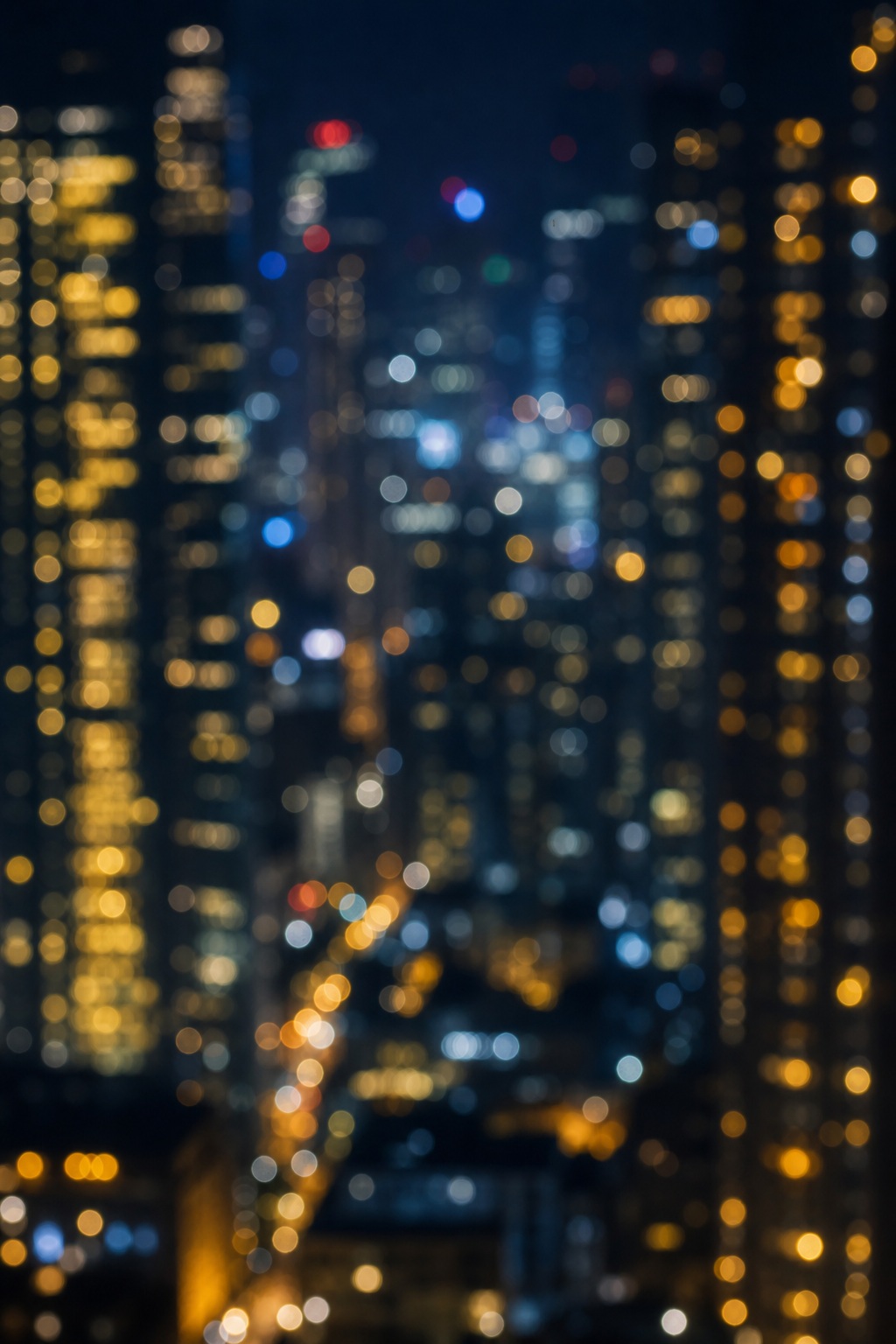 Blurred night city skyline with glowing blue and orange lights