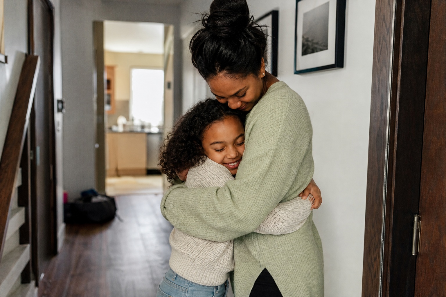 Mother hugging her child in a hallway at home