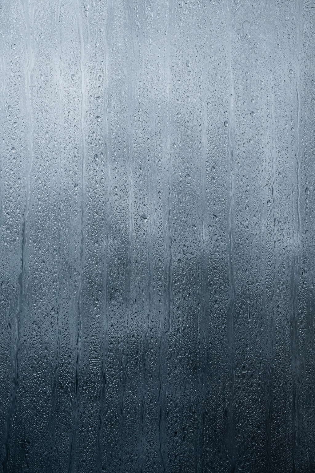 Vertical blue-gray rain glass texture with fine waterlike streaks and droplets