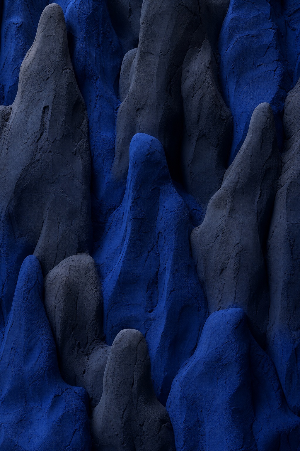 Deep cobalt blue matte clay mounds with sculptural shadows and organic texture
