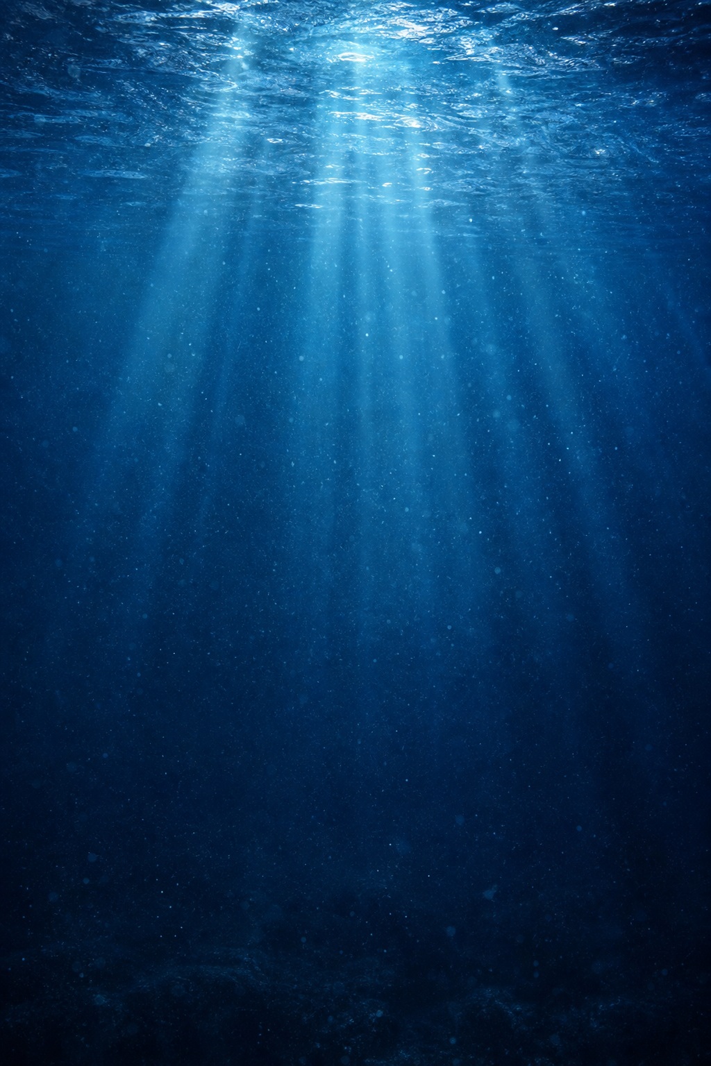 Blue underwater scene with sunbeams filtering through deep ocean water