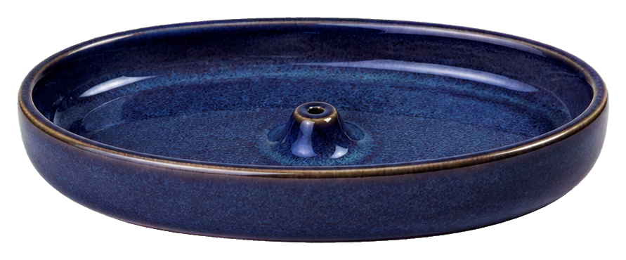 Indigo ceramic incense dish with a small center holder on a dark rimmed dish.