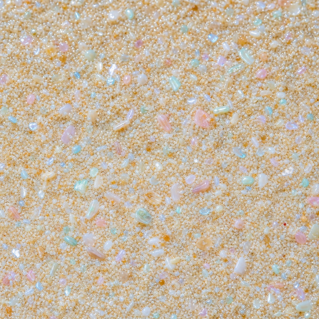 Pearlescent sand-like texture with soft blue and orange speckles