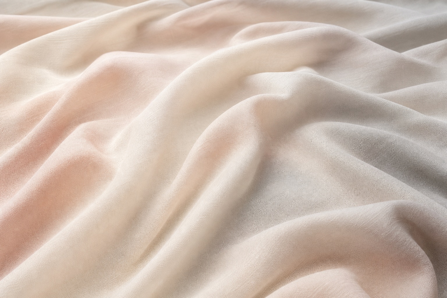 Soft ivory and blush fabric folds forming a smooth draped background