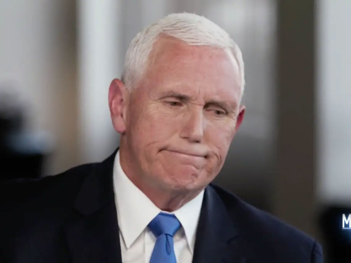 Portrait of Mike Pence in a suit and blue tie against a dark background