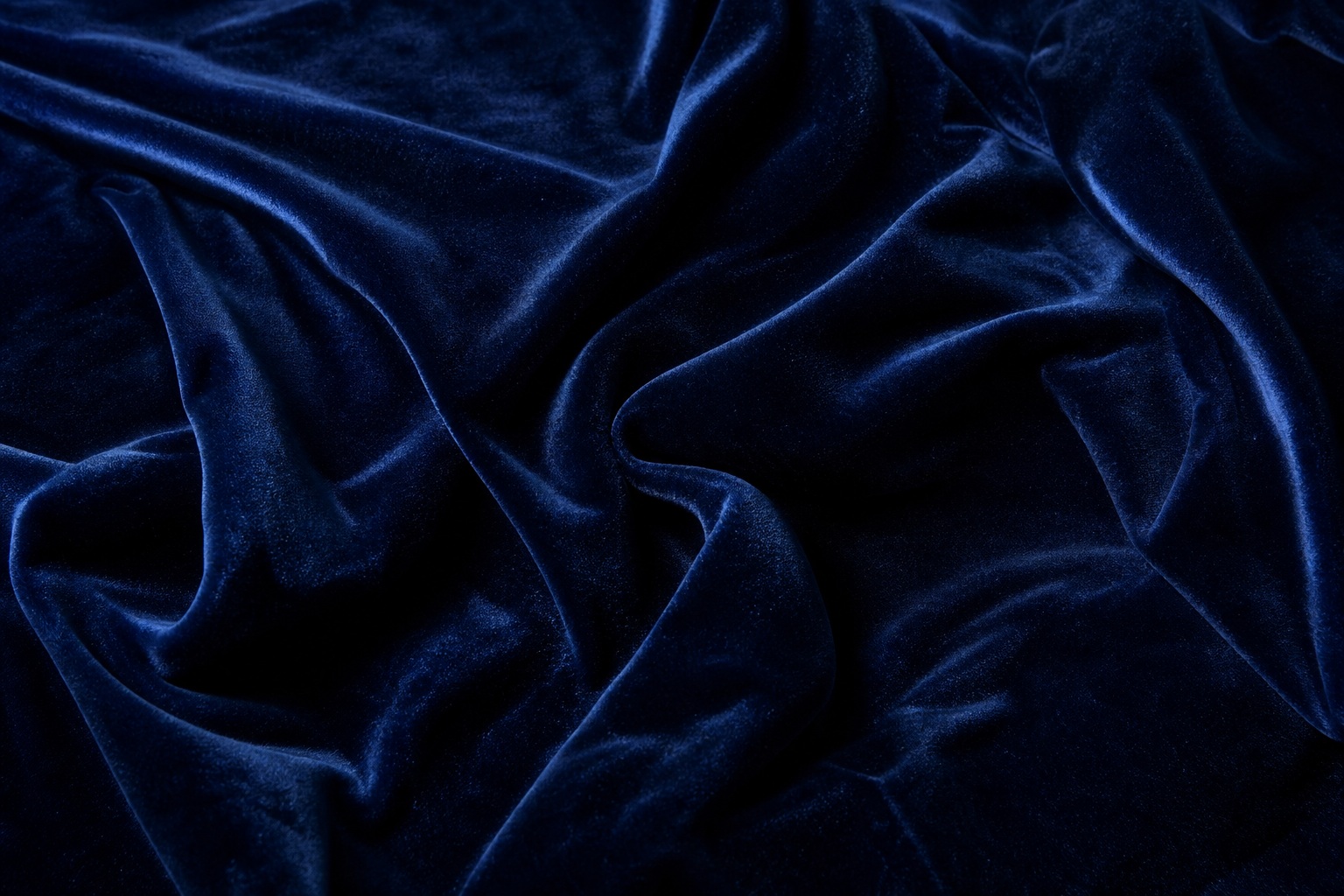 Deep navy velvet fabric with soft folds and rich textured highlights.