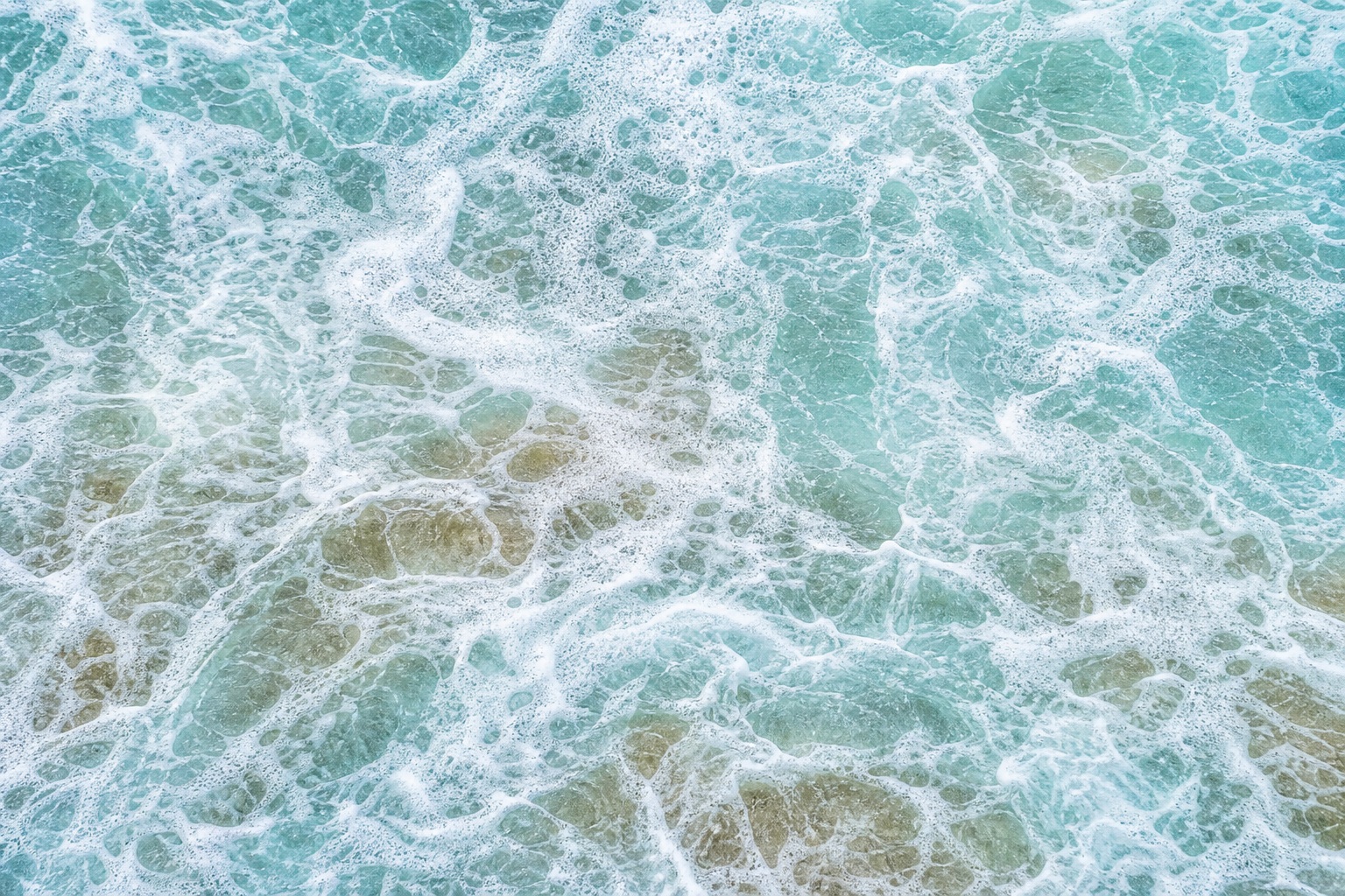 Abstract aqua water surface with white sea foam and dispersed bubble patterns