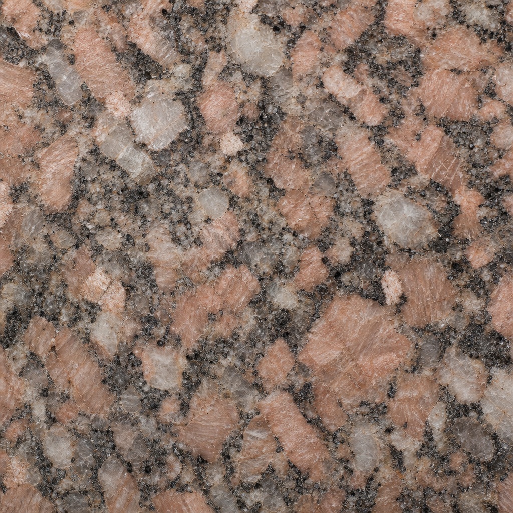 Rose granite surface with coarse mineral grain and speckled stone pattern