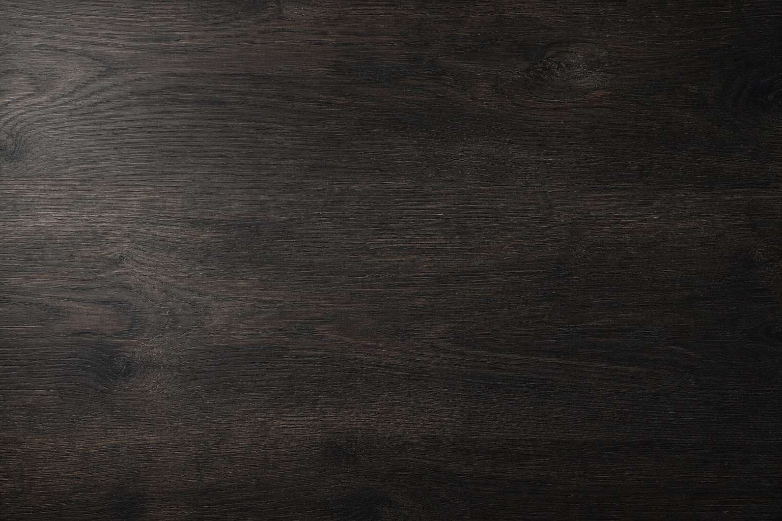 Dark charcoal woodgrain desk surface with a minimal, clean workspace look