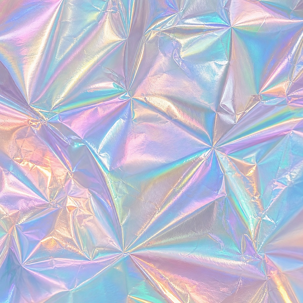 Pastel iridescent foil texture with folded reflective metallic surface.