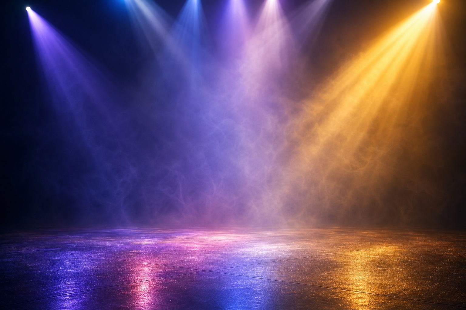 Blue, purple, and gold studio light rays shining over a dark empty floor.