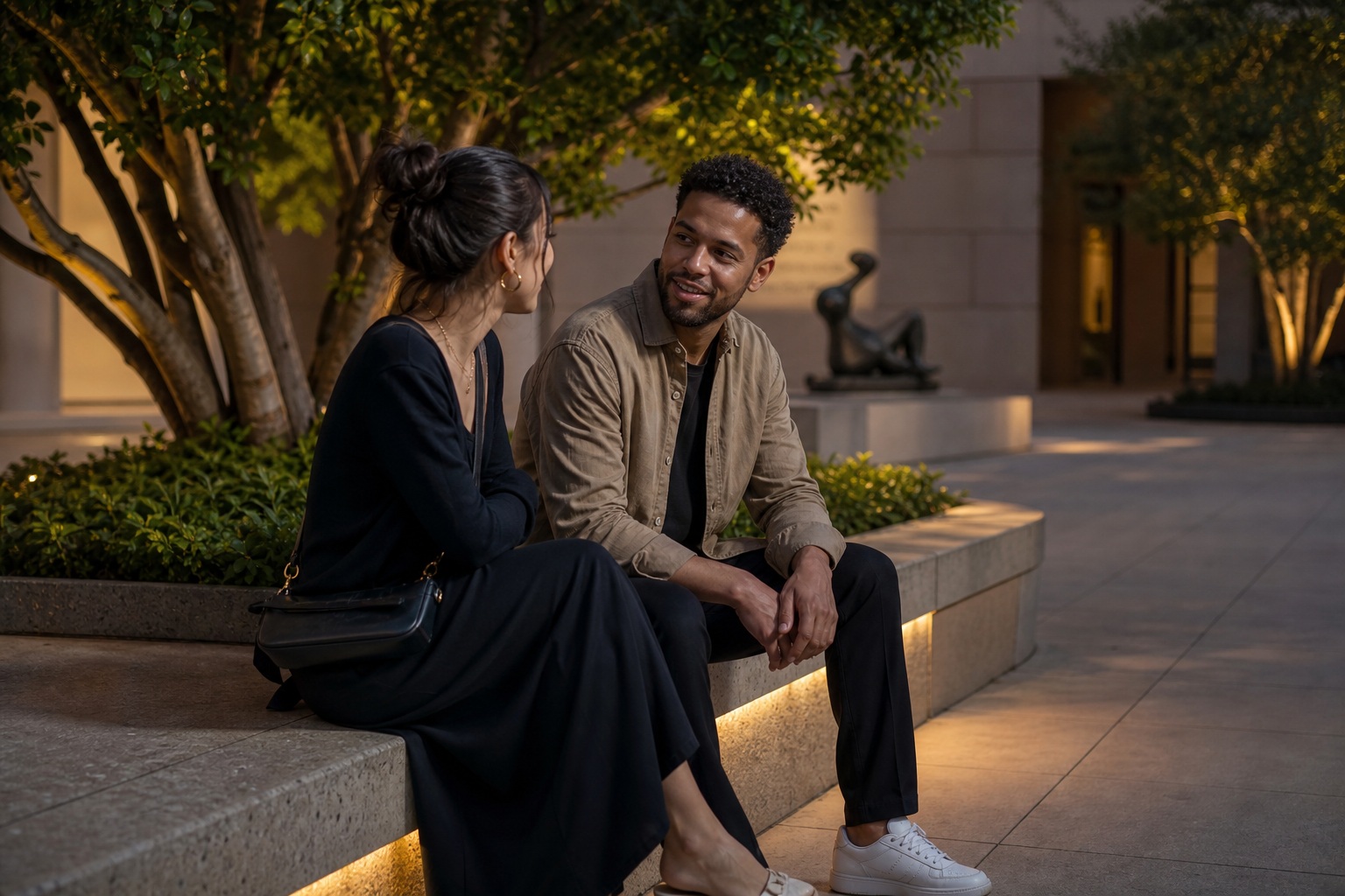 Couple sitting on courtyard steps and talking during a romantic evening date.