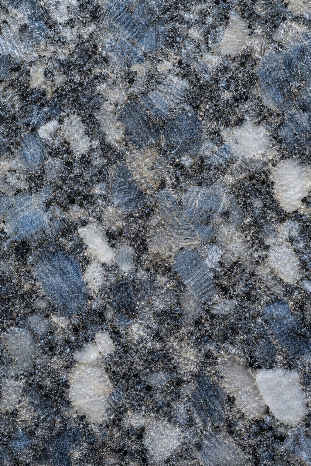 Blue gray polished granite surface with coarse mineral grain and mottled stone pattern.