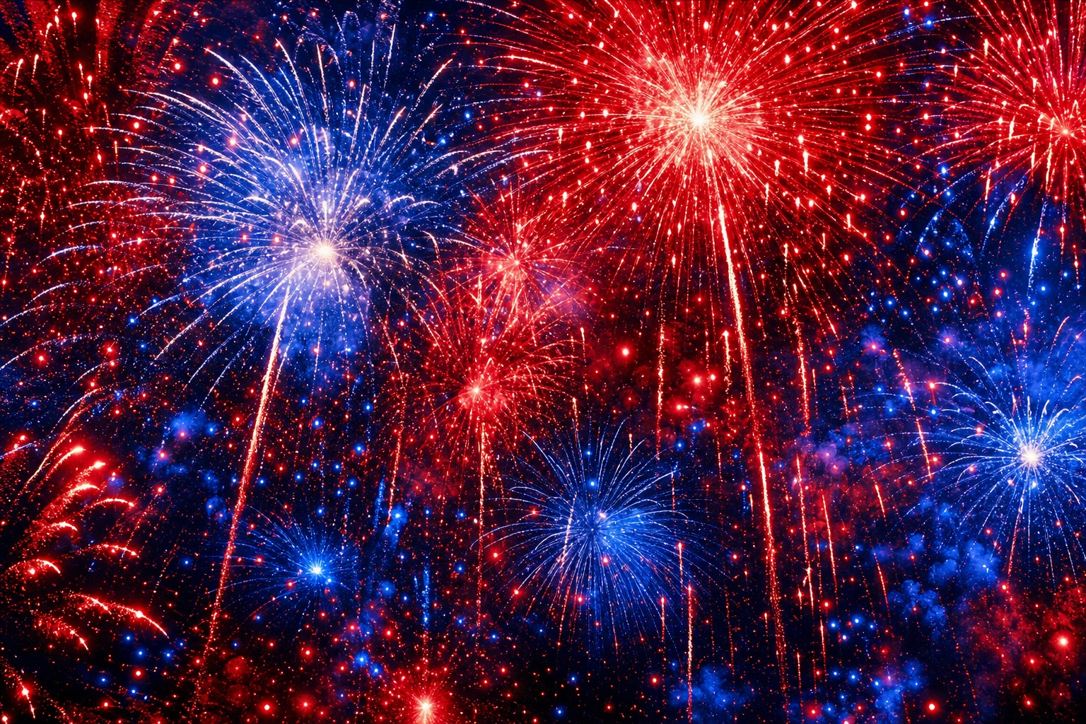 Abstract red, white, and blue fireworks bursting over a dark background