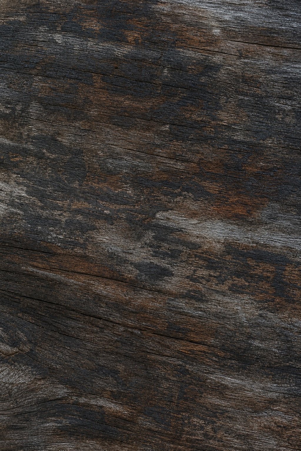 Dark weathered reclaimed wood with charcoal brown grain and traces of aged paint