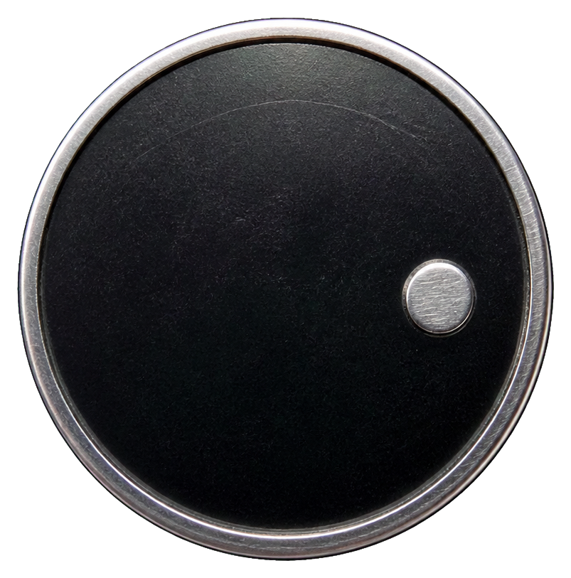 Black metal coin sticker with a small polished silver dot on the lower right