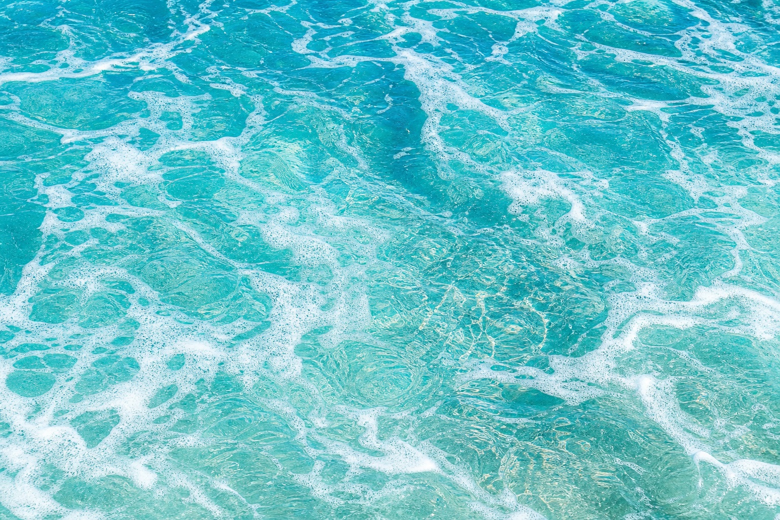 Blue ocean water with white foam and swirling wave texture