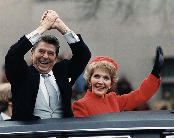 Ronald Reagan and Nancy Reagan waving from a car during an inauguration parade.