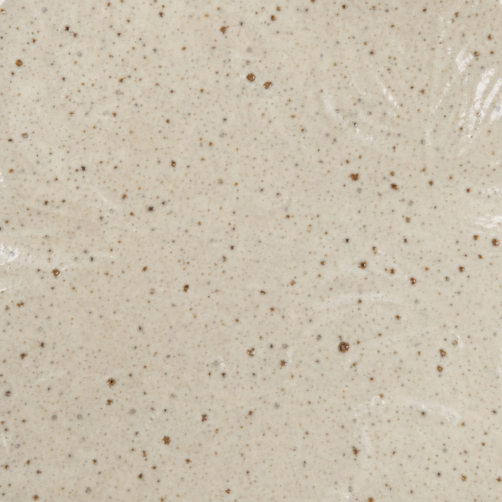Cream ceramic surface with fine speckled texture and subtle glaze marks