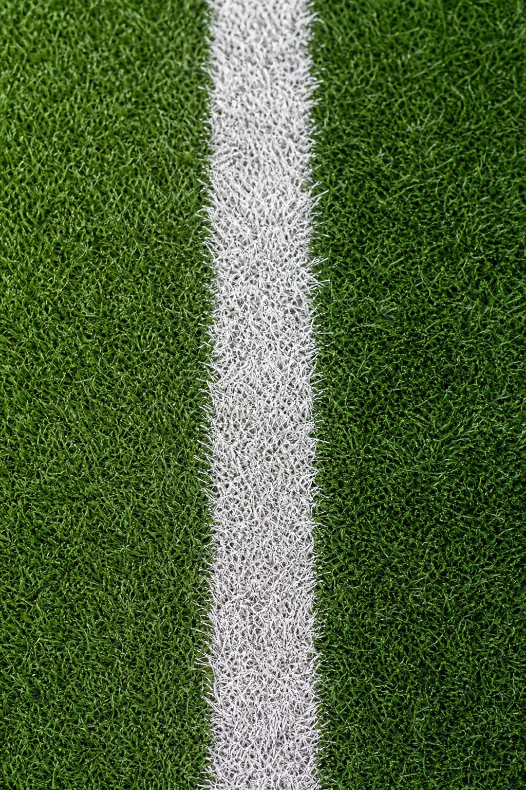 Close-up of green soccer turf with a white vertical field line.