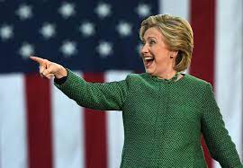 Hillary Clinton speaking onstage and pointing during a rally