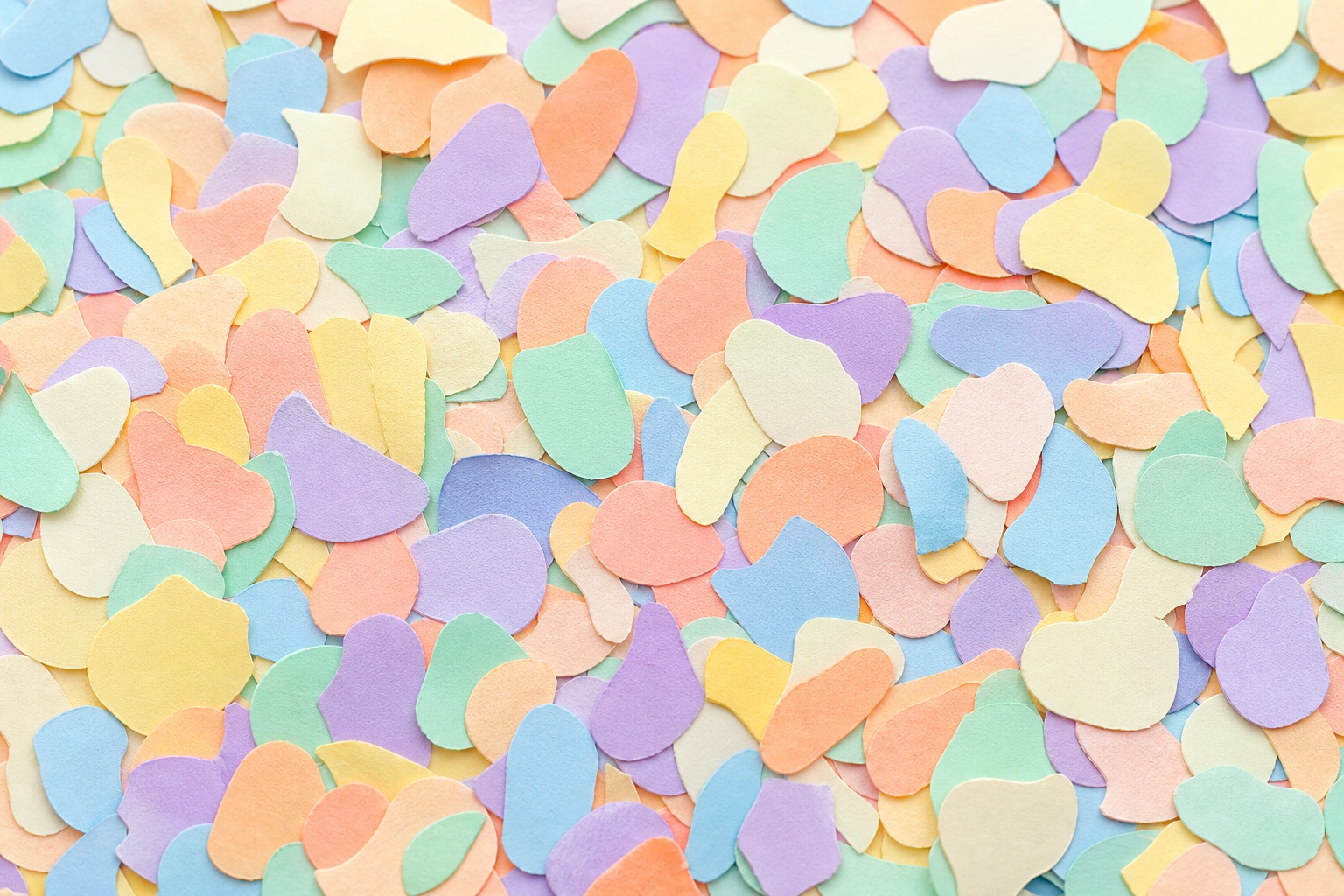 Pastel confetti-style paper fragments scattered across a colorful textured background
