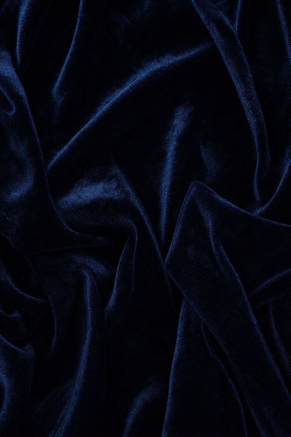 Dark vertical velvet fabric folds with soft highlights and deep shadow lines.