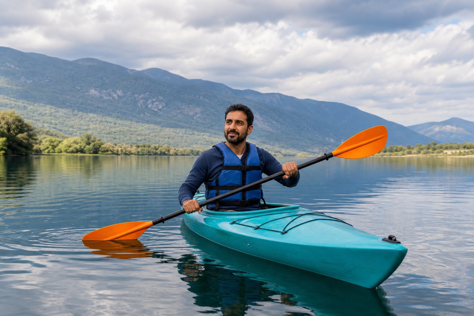 Man paddling a turquoise kayak on a calm mountain lake with orange oar blades.