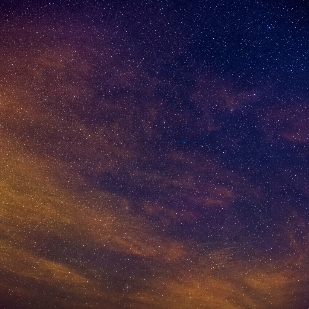 Gold and indigo night sky with stars and soft airglow haze