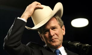 Man in a cowboy hat tipping his hat while standing at a microphone.