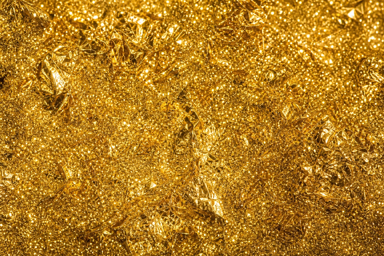Shimmering gold foil glitter texture with dense sparkling metallic flecks