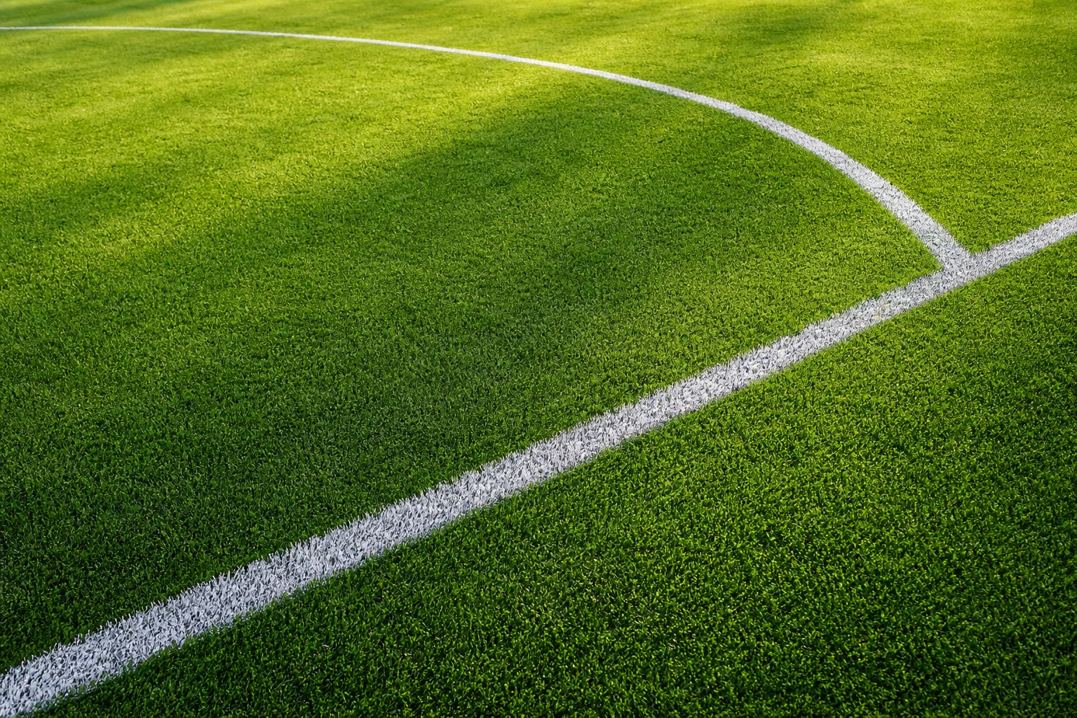 Green soccer turf with white chalk lines in a minimal landscape view