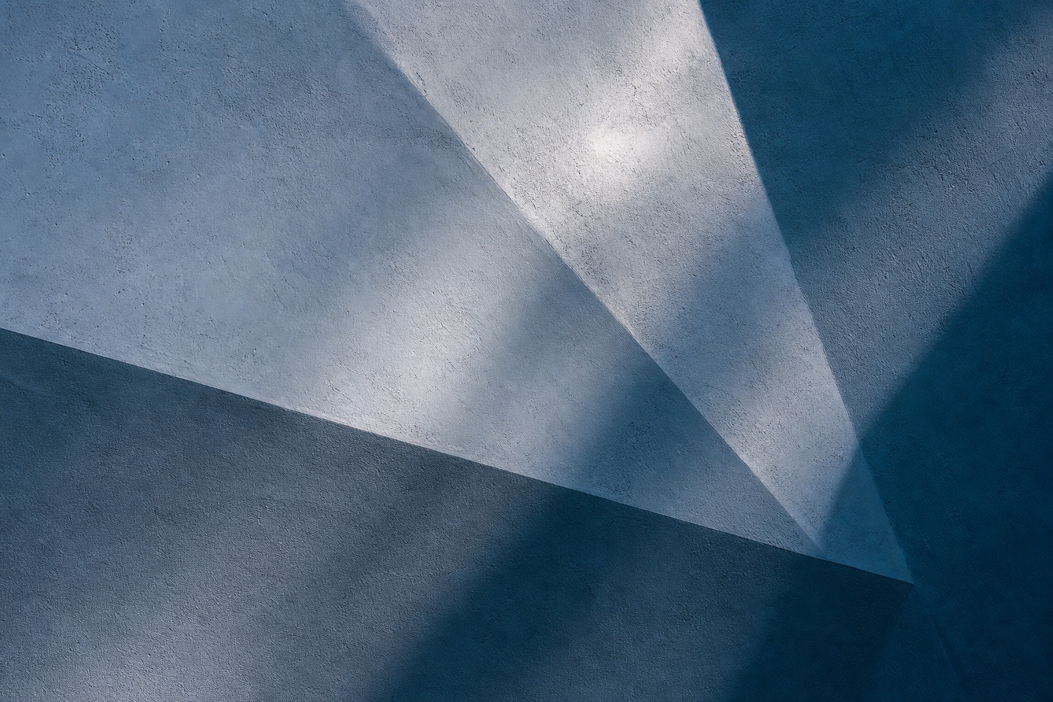 Abstract blue folded planes with sharp diagonal shadows and textured light.