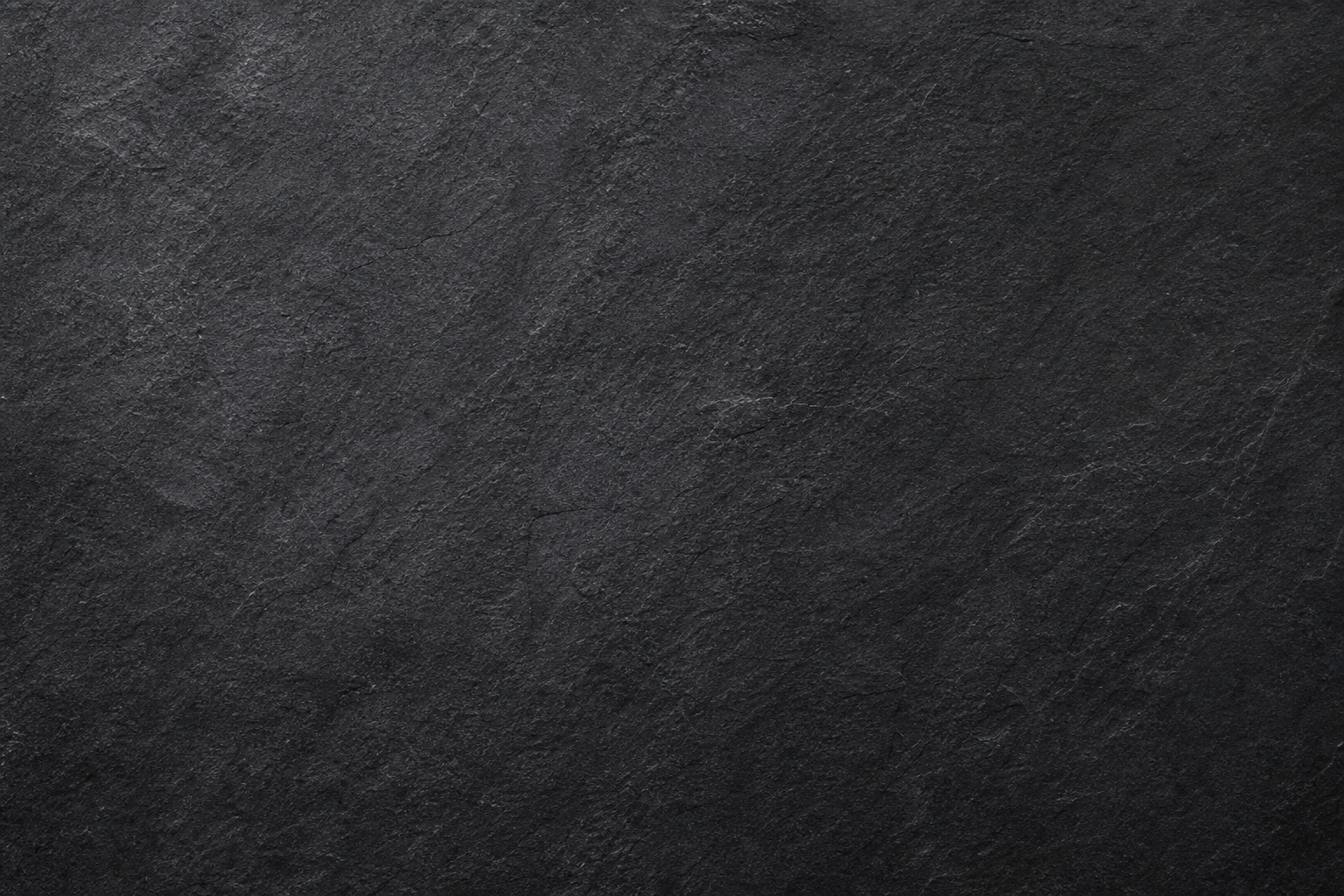 Dark charcoal stone texture with subtle grain and diagonal surface marks