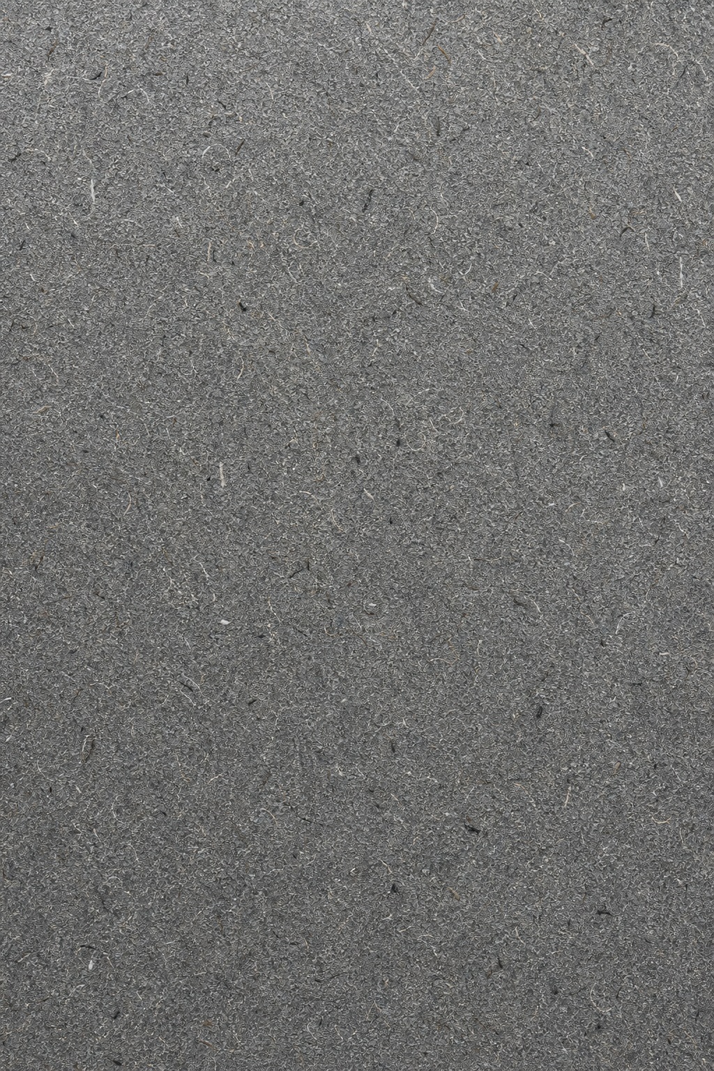 Gray recycled paper texture with fine grain and subtle fiber flecks