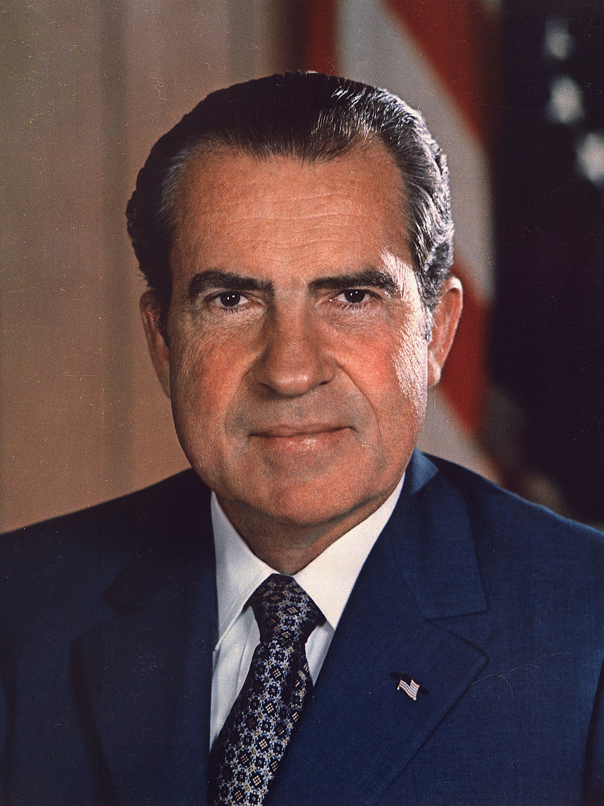 Official portrait of Richard Nixon in a dark suit and patterned tie