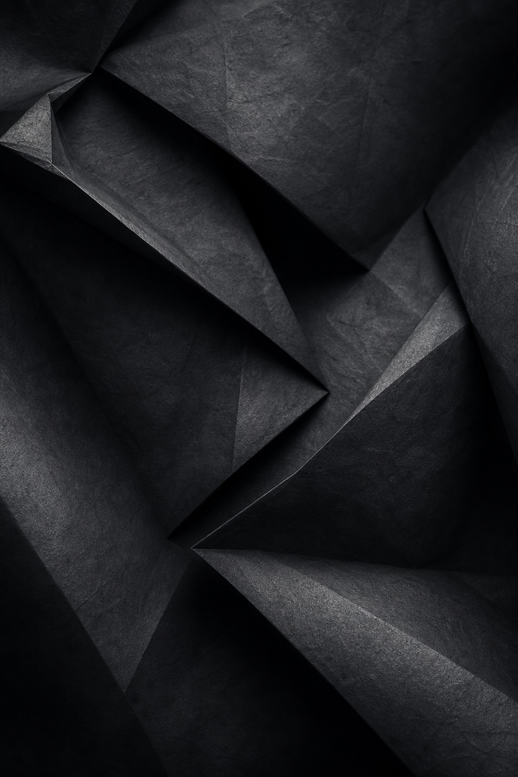 Dark folded paper-like abstract shapes with layered shadows and soft geometric depth.