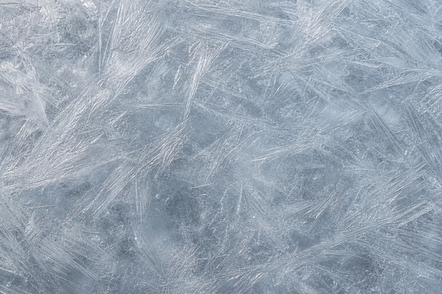 Silver-gray frost lines and icy texture across a frozen surface