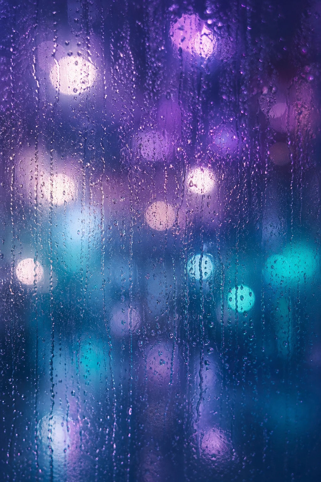 Blue and purple blurred lights glowing behind a rainy, textured surface
