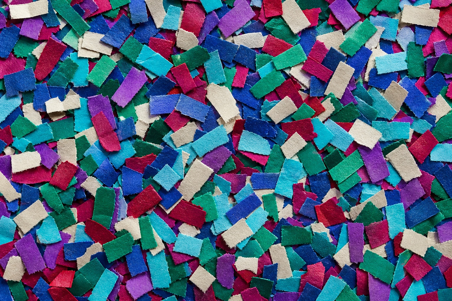 Colorful jewel-toned confetti paper dashes scattered across a textured background.