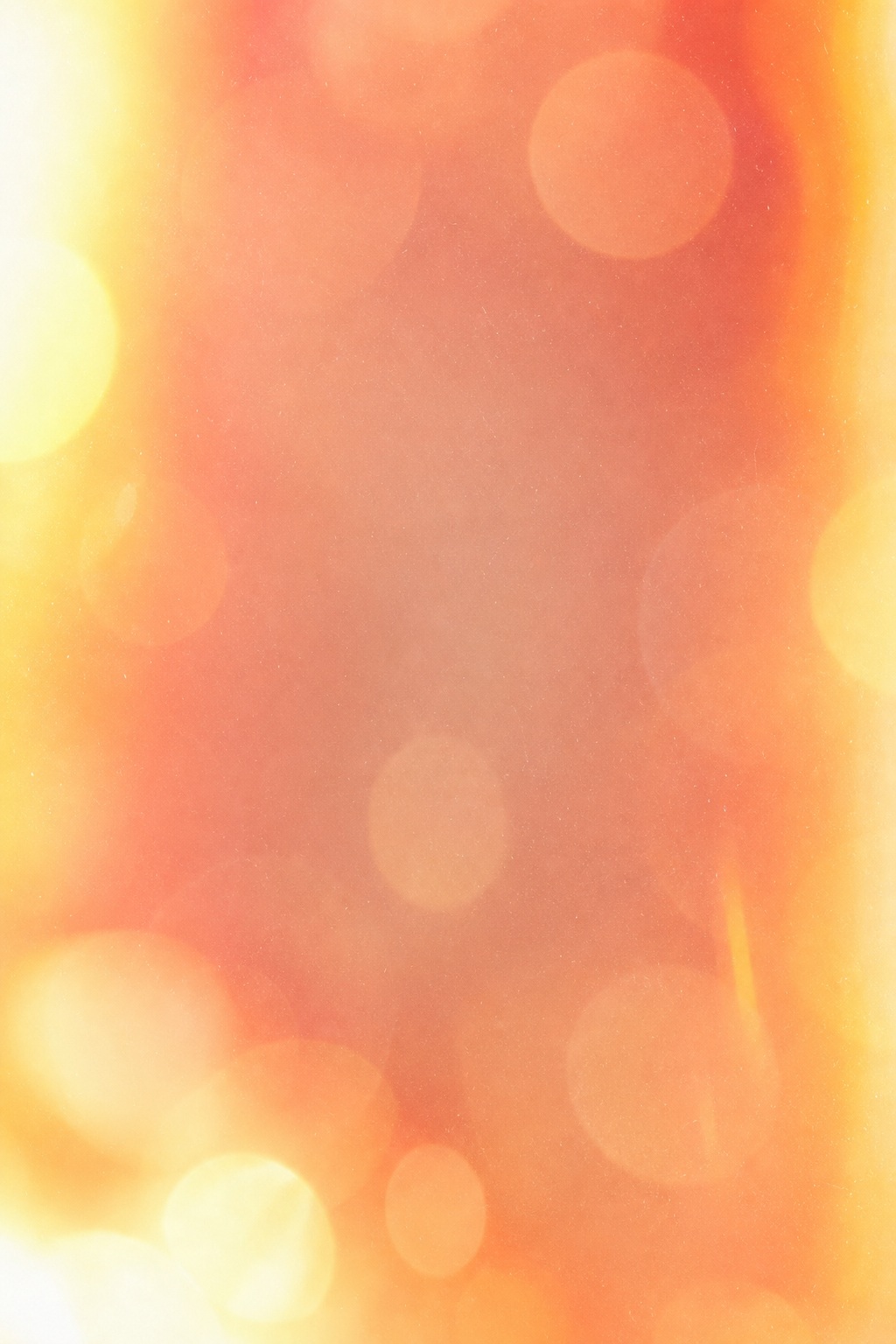 Soft amber and pink abstract background with glowing bokeh and light leak effects