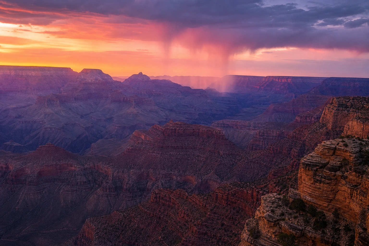 Dramatic Grand Canyon landscape at dusk with layered sandstone mesas and glowing sky